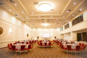 a banquet hall with tables and chairs and a screen at Kobuleti Georgia Palace Hotel & Spa in Kobuleti +107 photos