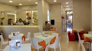 a restaurant with white tables and white chairs and a person at Licia B&B in Ortona