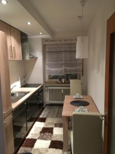 una pequeña cocina con una mesa de madera y un fregadero en Augsburger Apartment, en Augsburg