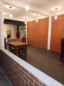a room with a table and a brick wall at Serenity Sigiri Resort in Sigiriya +19 photos