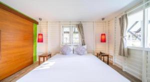 a bedroom with a large white bed and a window at Baan Supparod in Ko Samed