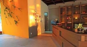 a kitchen with an orange wall and a counter at Baan Supparod in Ko Samed