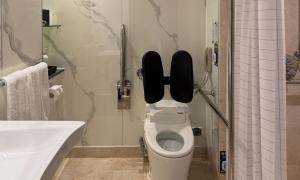a bathroom with a toilet with the lid up at Geoje Samsung Hotel in Geoje