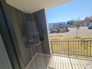 a balcony with a fireplace and a view of a parking lot at Northview APARTMENTS SELF CATERING in Pretoria