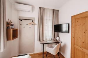 a room with a desk and a tv and a chair at Weingut Pugl in Leibnitz