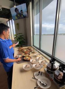 a man standing in front of a table of food at D'Mount Sky Homestay Syariah in Bukittinggi