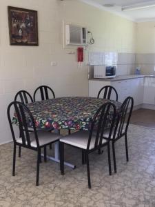 mesa de comedor con sillas y cocina en Snowy River Lodge Motel en Orbost