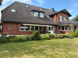a red brick house with a large yard at Landhaus Jägerhof in Börnsdorf