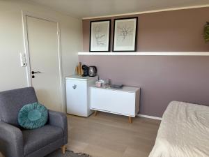 a bedroom with a bed and a chair and a table at Northern Suite in Tromsø