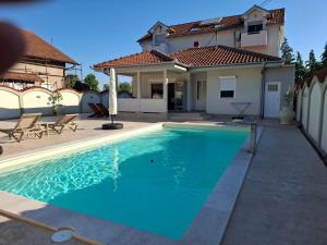 a swimming pool in front of a house at Serbian home - free parking - Bazen se doplaćuje in Krnjača