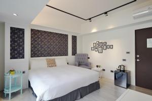 a bedroom with a white bed and a blue chair at 品朵行旅 台中 逢甲館 Pin INN in Taichung