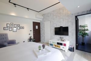 a bedroom with a bed and a tv on a wall at 品朵行旅 台中 逢甲館 Pin INN in Taichung