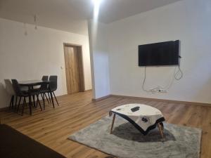 a living room with a table and a tv on the wall at Ferienwohnung KEMS in Gundelsheim