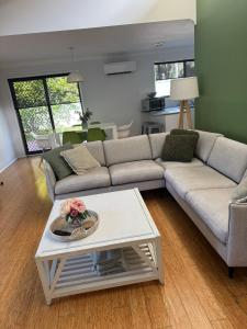 a living room with a couch and a table at Frangipani in Shoal Bay