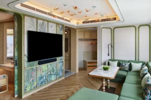 a living room with a couch and a flat screen tv at Shangri-La Kunming in Kunming