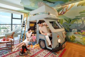 a family sitting in a toy car in a room at Shangri-La Kunming in Kunming