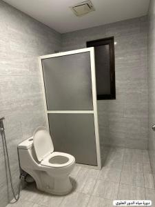 a bathroom with a toilet and a shower stall at marjan beach in Dhahran