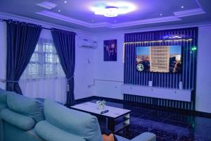 a living room with a blue couch and a table at Living Space Service Apartment in Mama