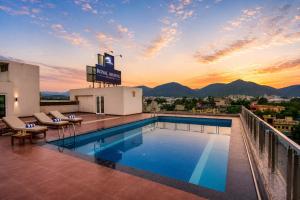 a pool on the roof of a building with a sunset at Hotel Royal Aravali in Udaipur