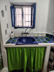 a bathroom with a sink with a green curtain around it at La Muralla in Yunquera