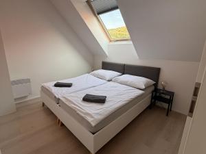 a bedroom with a bed with white sheets and a window at Rezidence Pavlov in Pavlov