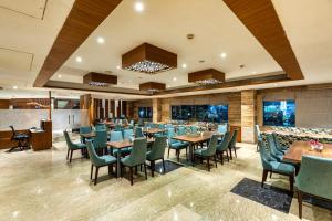 a restaurant with tables and chairs and windows at Hotel Royal Aravali in Udaipur