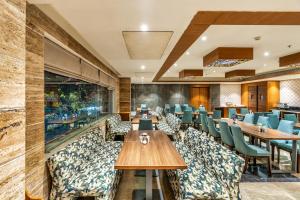 a restaurant with wooden tables and blue chairs at Hotel Royal Aravali in Udaipur +40 photos
