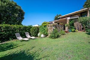 two chairs sitting in a yard next to a house at Angolo di Paradiso in Punta Ala