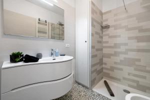 a white bathroom with a sink and a shower at Angolo di Paradiso in Punta Ala +26 photos