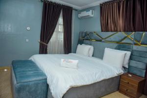 a bedroom with a large bed and a window at Living Space Service Apartment in Mama