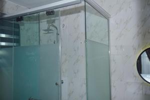 a shower with a glass door in a bathroom at Living Space Service Apartment in Mama +30 photos