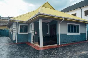 a small blue and white house with a yellow roof at Living Space Service Apartment in Mama