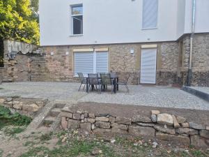 a patio with a table and chairs in front of a building at Ferienwohnung KEMS in Gundelsheim