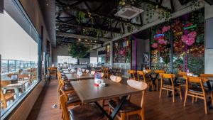 a restaurant with wooden tables and chairs and flowers on the walls at Continent CentrePoint Makassar in Pampang