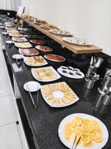 a buffet with plates of food on a table at Hotel City Land Tashkent in Yakkasaray