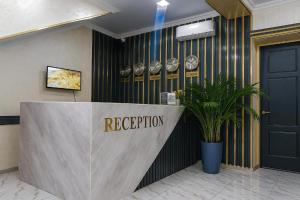 a reception desk in a lobby with a door at Hotel City Land Tashkent in Yakkasaray