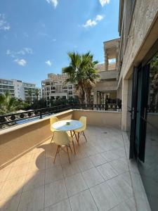 a patio with two chairs and a table on a balcony at ЛУКСОЗЕН АПАРТАМЕНТ В 4 звезден хотел in Golden Sands