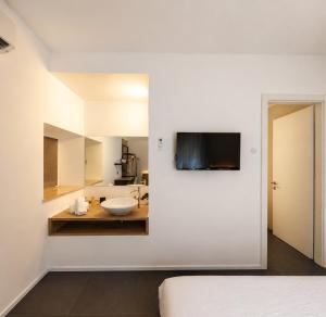 a white bathroom with a sink and a mirror at Le Palme City Rooms & Breakfast in Trento