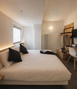a bedroom with a large white bed with a window at Le Palme City Rooms & Breakfast in Trento