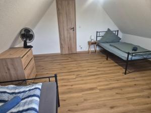 a bedroom with a bed and a wooden floor at Ferienwohnung KEMS in Gundelsheim