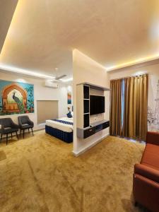 a bedroom with a bed and a tv and a couch at Lucknow Courtyard in Lucknow