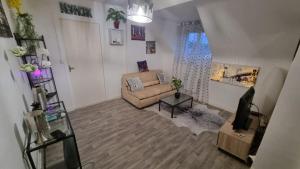 a living room with a couch and a tv at De Manhattan à la savane in Montbard