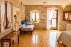 a room with a bed and a couch and a table at Villa Alma Komiza Island Vis in Komiža