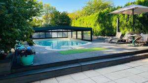 a swimming pool with a gazebo in a yard at Les jardins d'armance in Le Valdahon