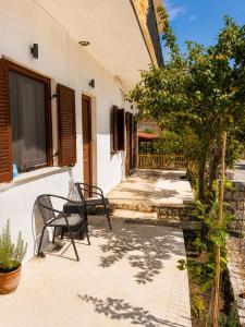 a patio with two chairs and a building at Villa Rozalia in Konitsa