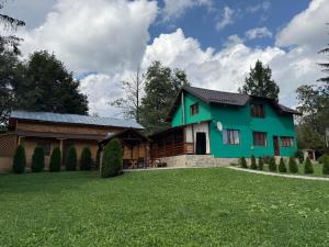 a green house with a large yard at La Canton Cheia in Cheia