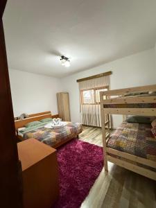 a bedroom with two bunk beds and a purple rug at La Canton Cheia in Cheia
