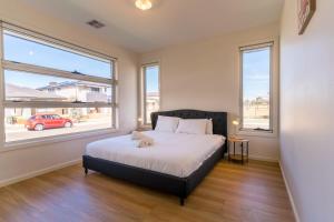 a bedroom with a bed with a dog laying on it at Light-Filled Werribee Escape in Werribee
