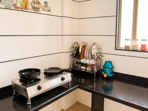 a kitchen with a stove with pots and pans on it at Elite Nest Stay in Nashik +5 photos