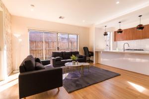 a living room with a couch and a table at Light-Filled Werribee Escape in Werribee